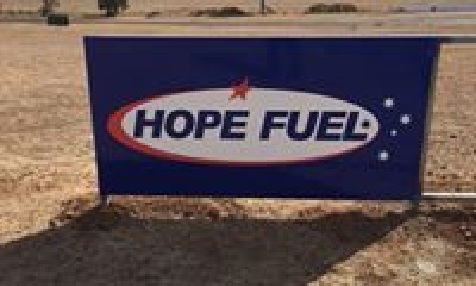 A blue sign that says `` hope fuel '' is sitting on the ground.