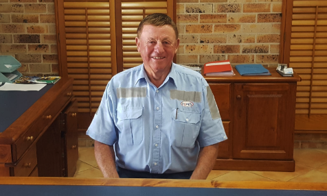A man in a blue shirt is sitting at a desk