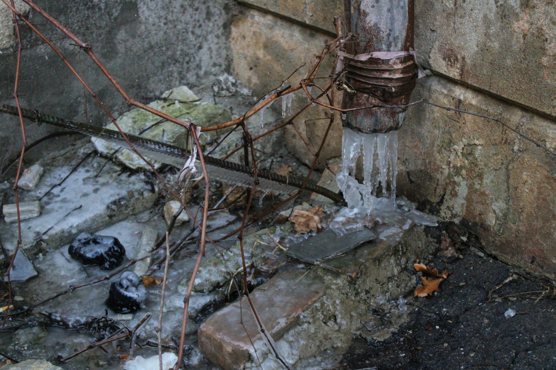Water running from a faucet into a white bathroom sink drain.