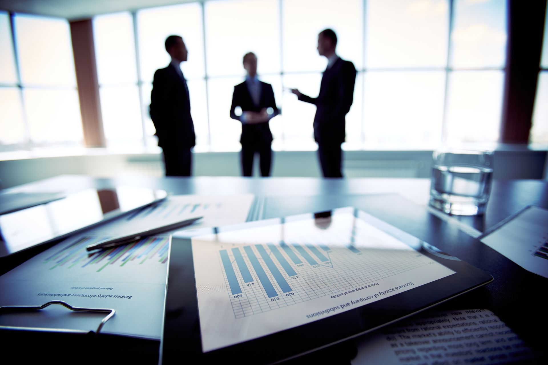 Executivos analisando documentos financeiros em uma operação estruturada empresarial
