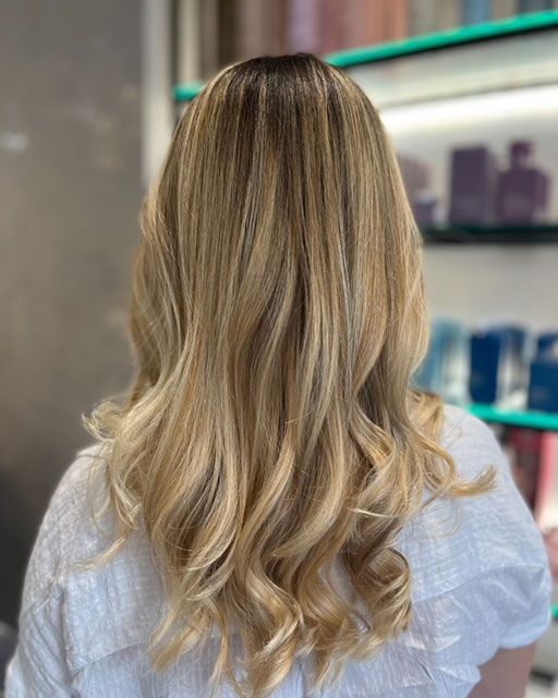 Back view of wavy blonde hair in a salon setting