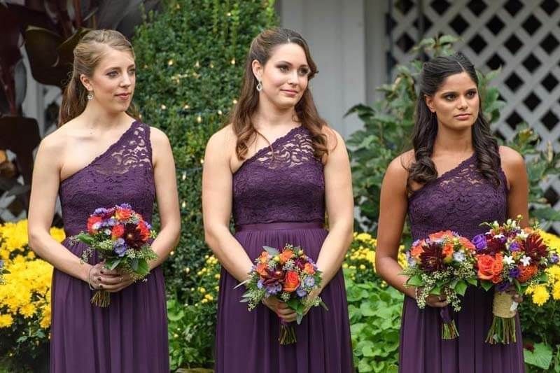 Bridesmaids in purple gowns with hair styled for the wedding