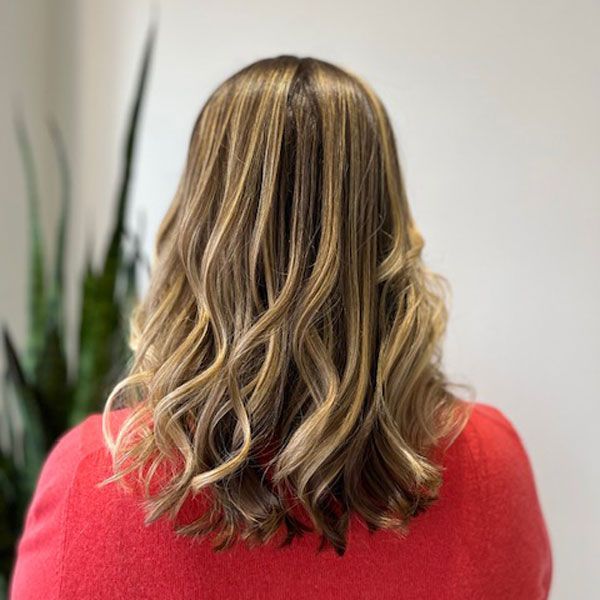 Back view of shoulder-length wavy blonde hair with darker lowlights