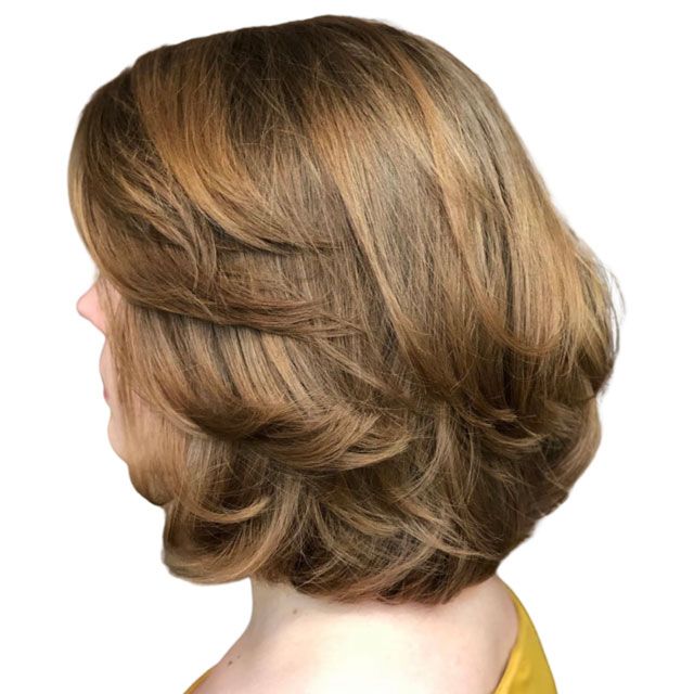 Side view of a layered short bob haircut in light brown with blonde highlights
