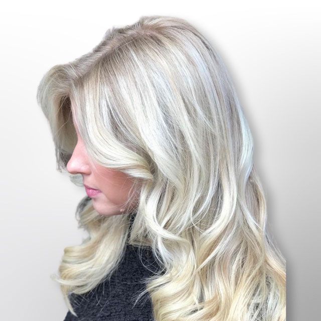 Side profile of a woman with long wavy platinum blonde hair