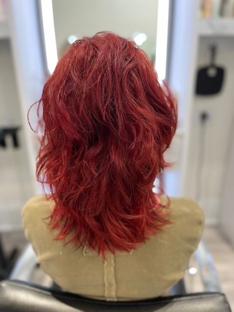 Red wavy wig on a mannequin head in a salon