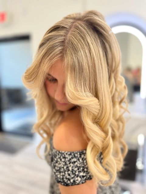 Woman with long blonde curls looking down
