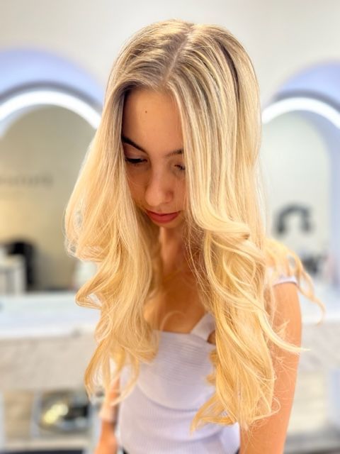 Young woman with long blonde hair looking down
