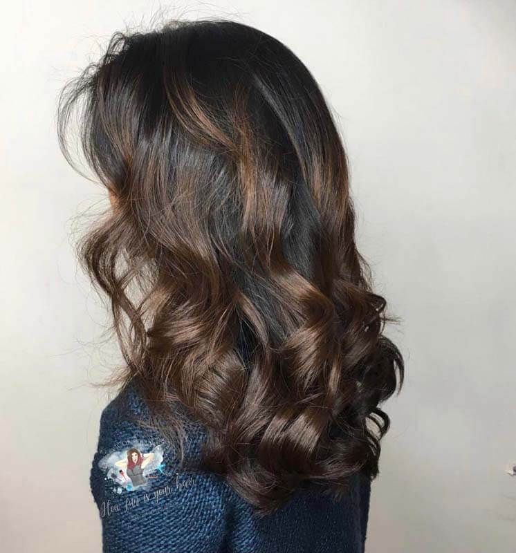 Side view of long wavy dark brown hair with subtle highlights