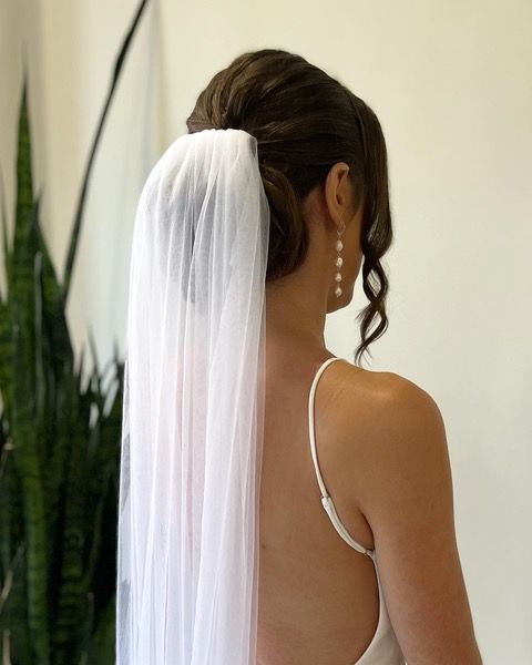 Bride seen from behind in a white veil and dress