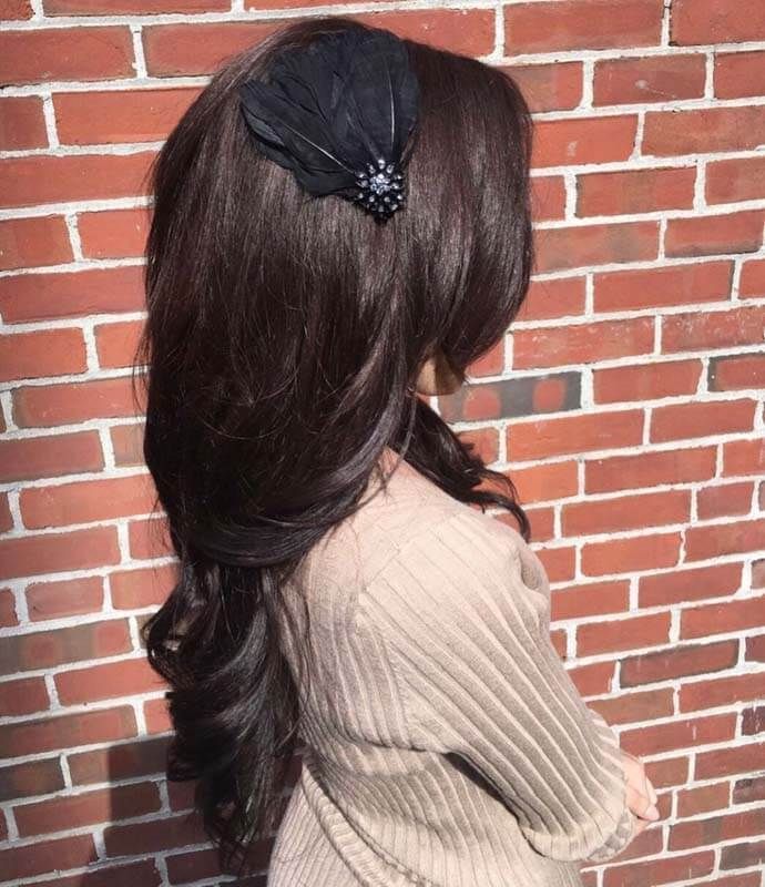 Woman with long dark hair and a black bow