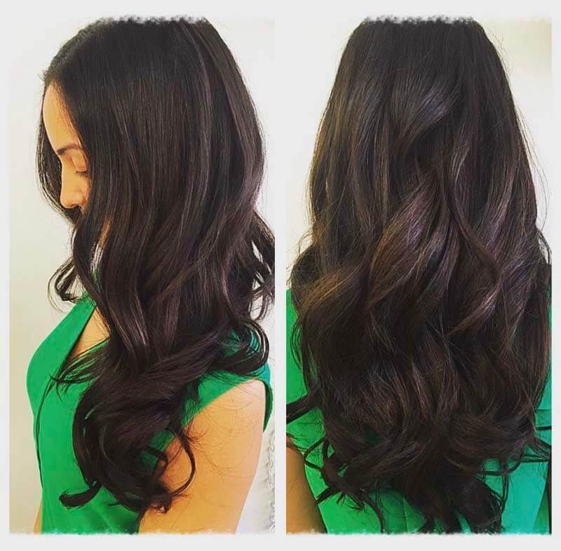 Side and back views of long, dark wavy hair with subtle brown highlights