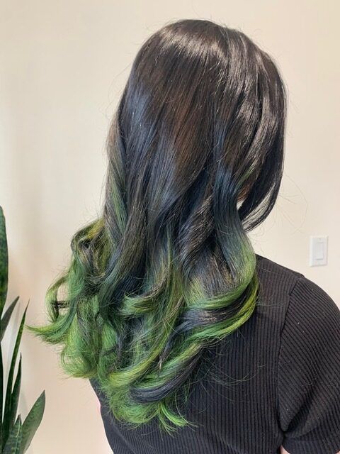 Person with long black hair fading to green at the ends