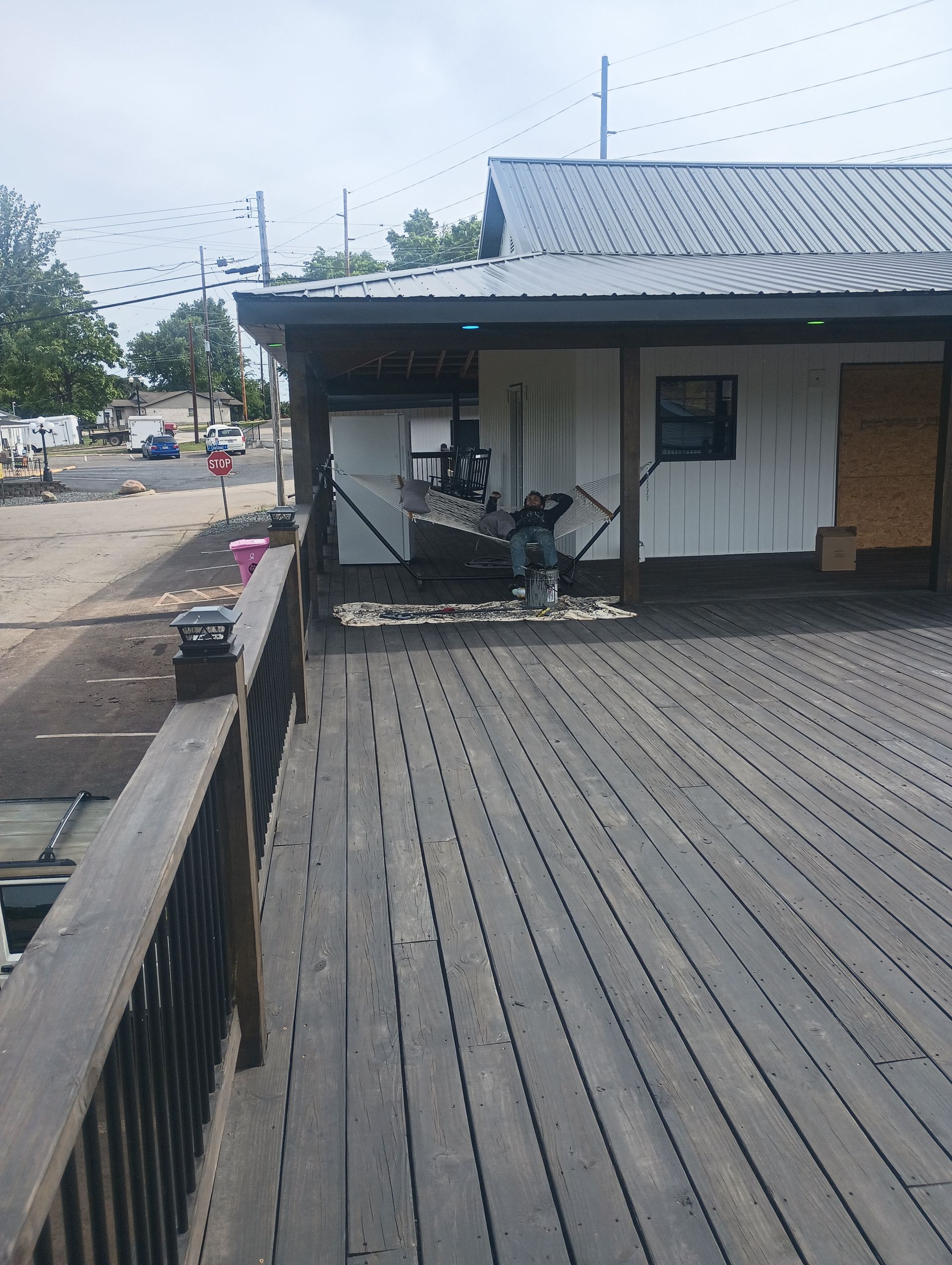 Wooden boardwalk leading to a small white building with a gray roof and parked scooters.