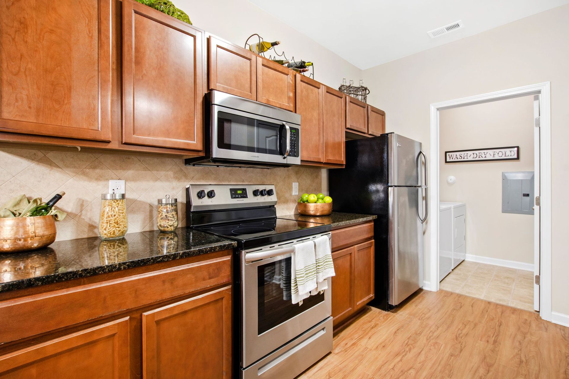 Kitchen with wooden cabinets, stainless steel appliances, and granite countertops at Jack Britt.