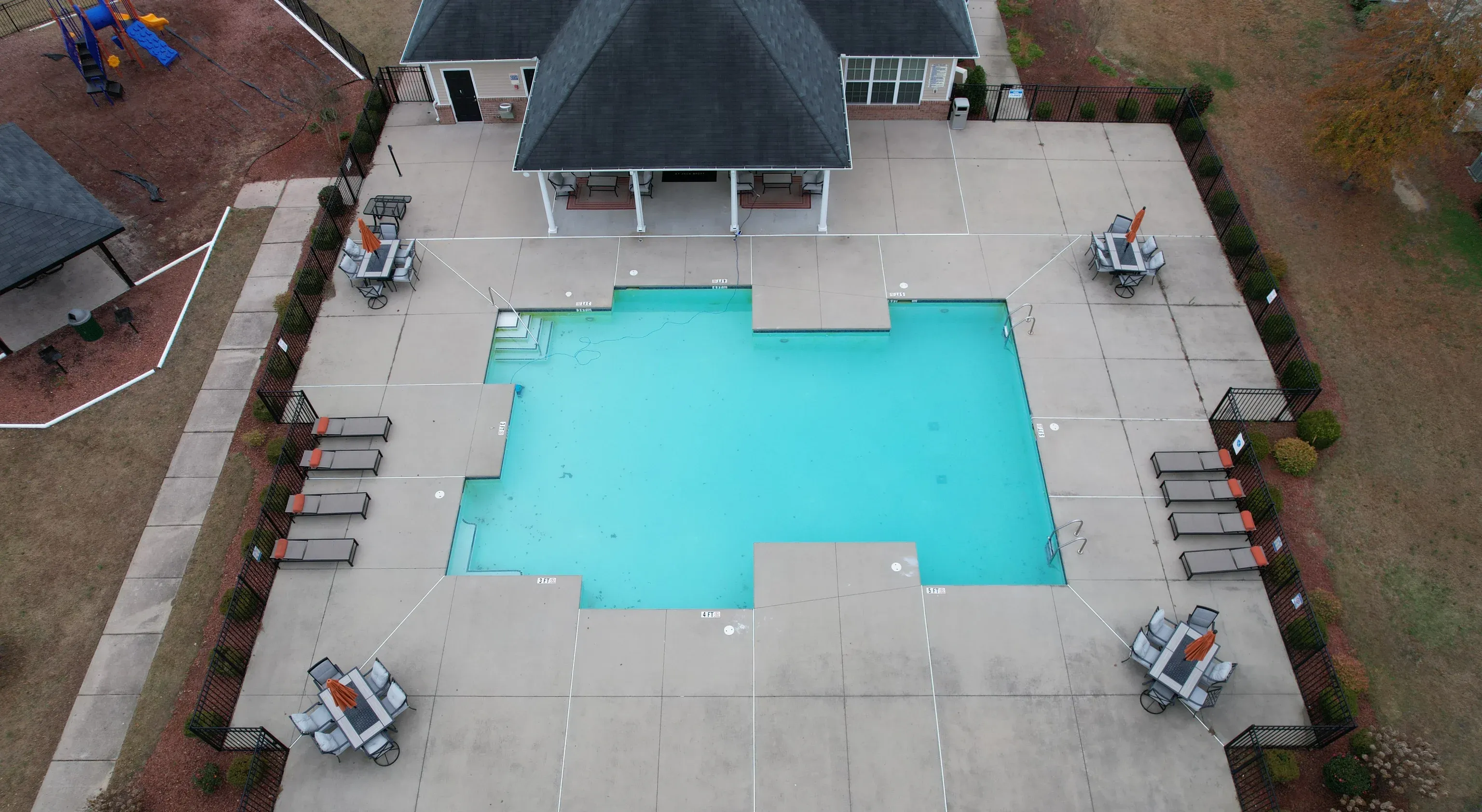 Aerial view of a residential community pool with lounge chairs and a clubhouse at Jack Britt.