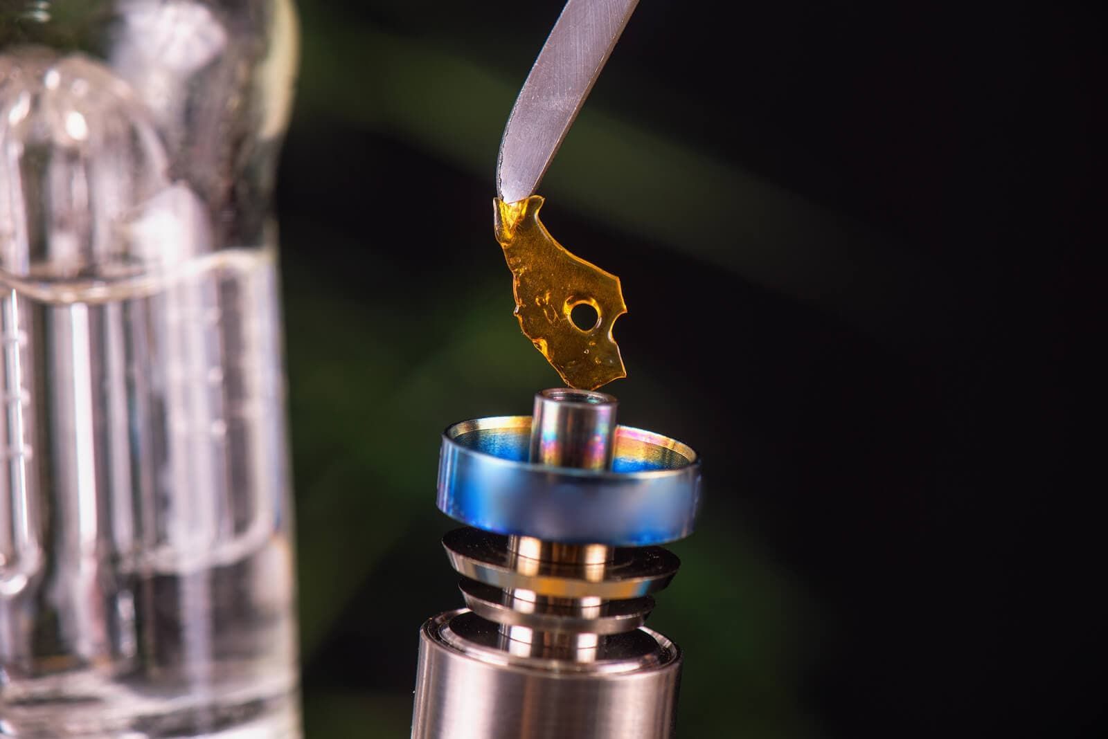 Cannabis concentrate being smoked on a titanium nail, black background
