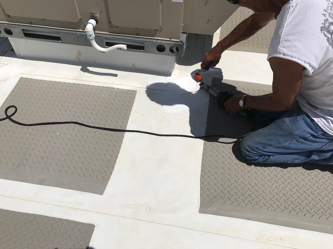 Person connecting wires on solar panel frame on rooftop, wearing safety gloves.