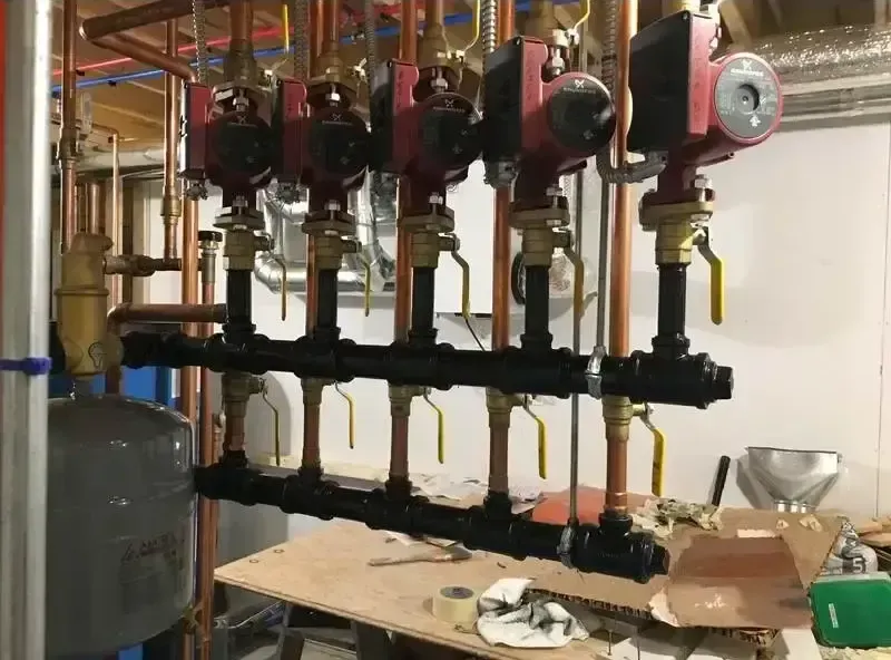 A bunch of pipes are hanging from the ceiling in a room.