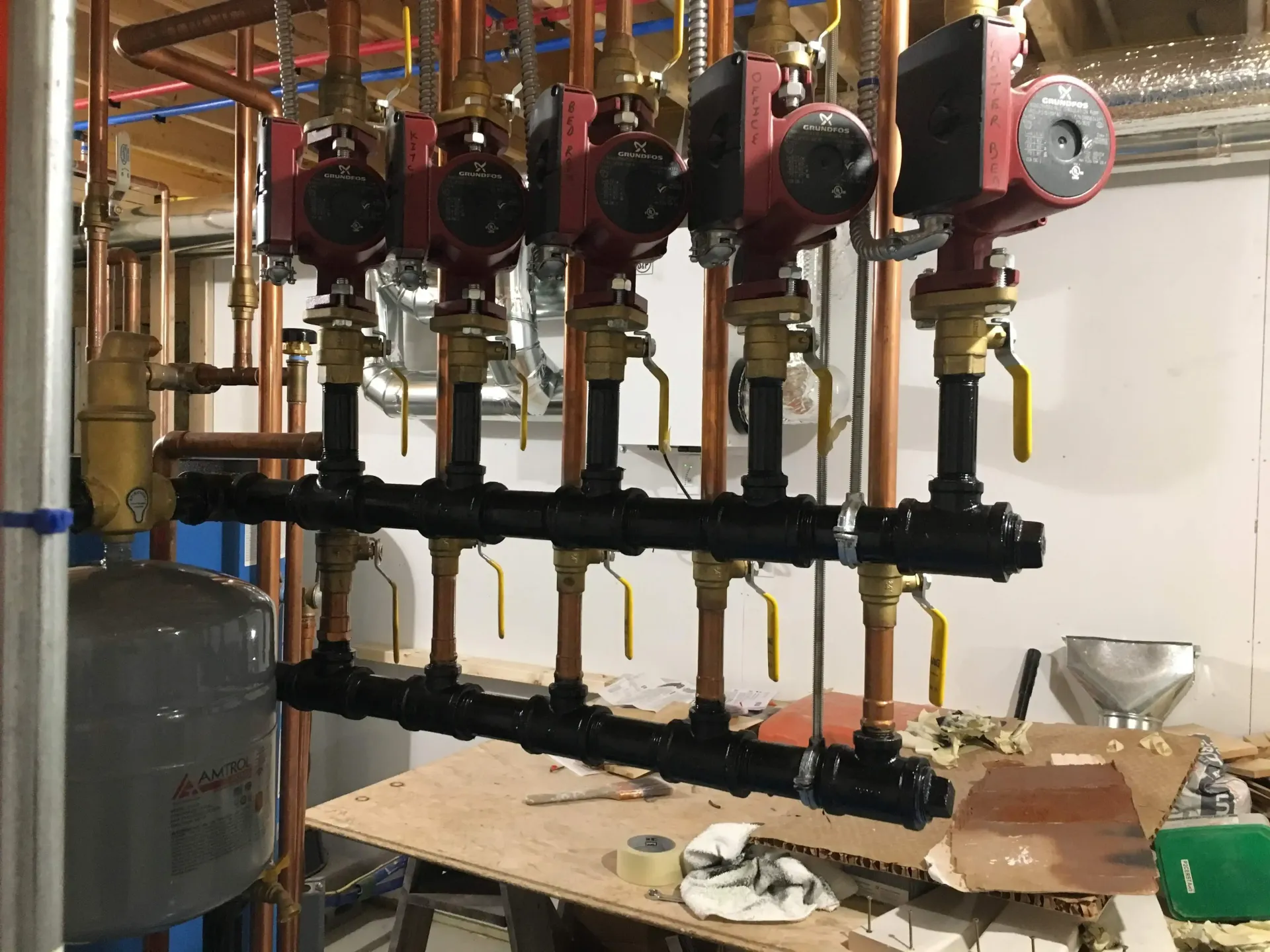 A bunch of pipes are hanging from the ceiling in a room.