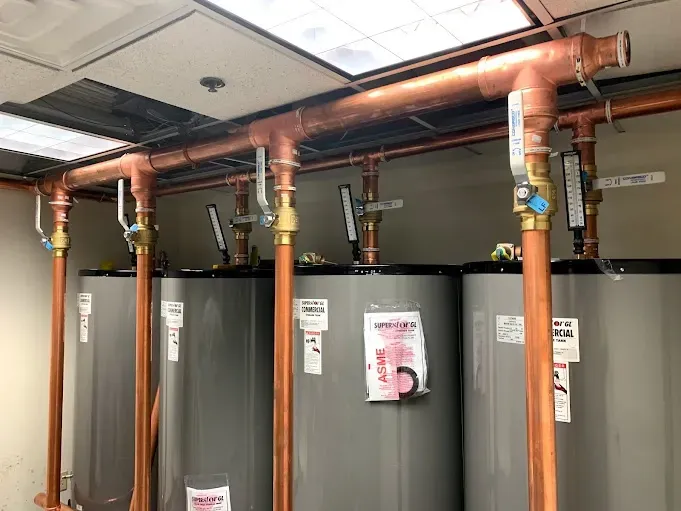 A room filled with water heaters and copper pipes.