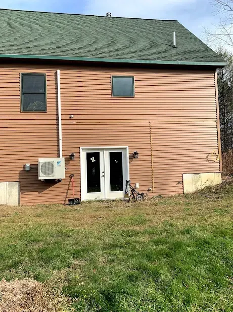 The back of a house with a green roof and a sliding glass door.