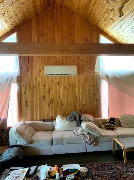 A living room with a couch and a ceiling fan.