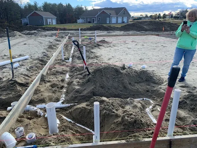 A woman is standing in the middle of a construction site.