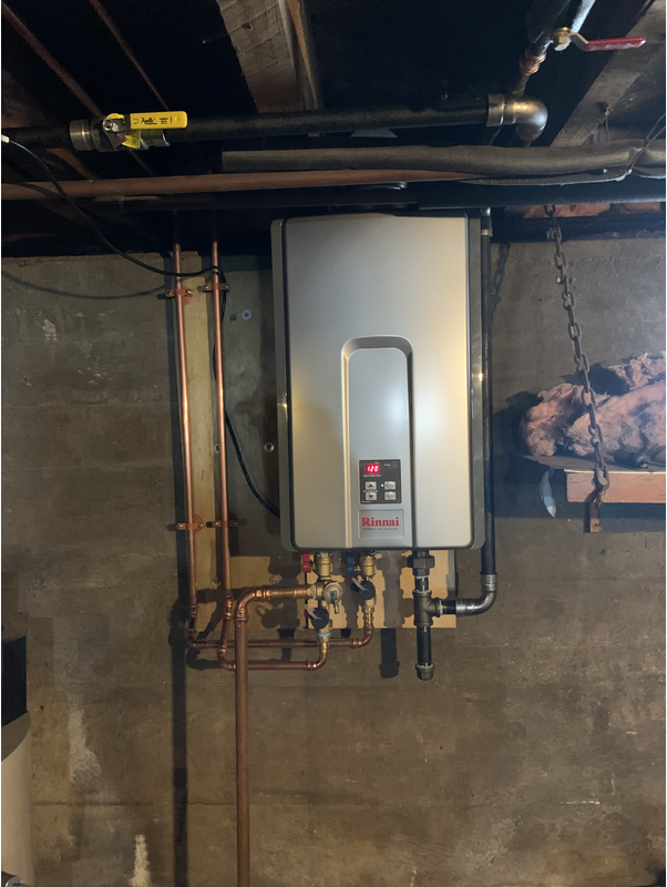 A water heater is hanging from the ceiling in a basement