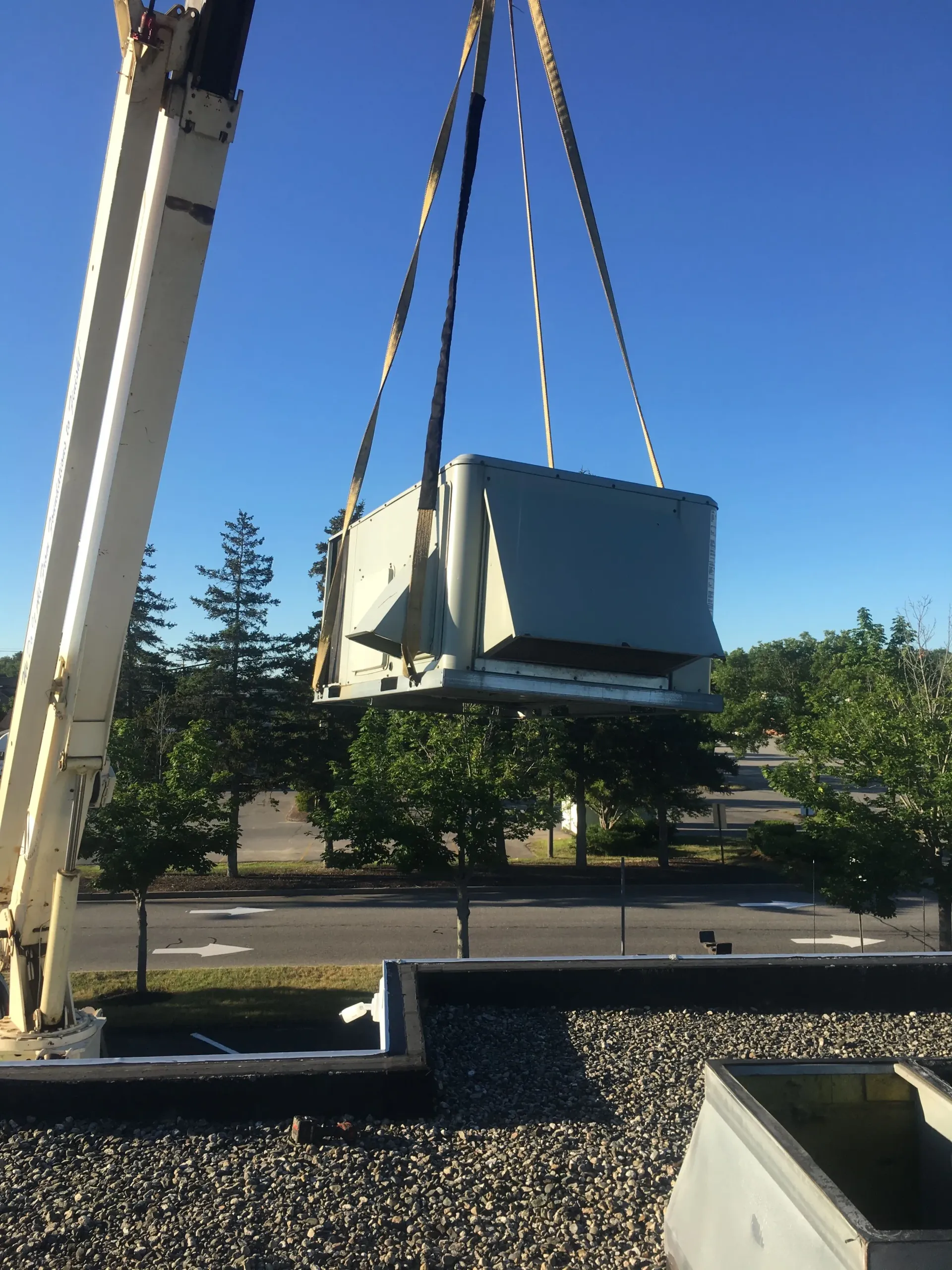 A large box is being lifted by a crane on top of a building