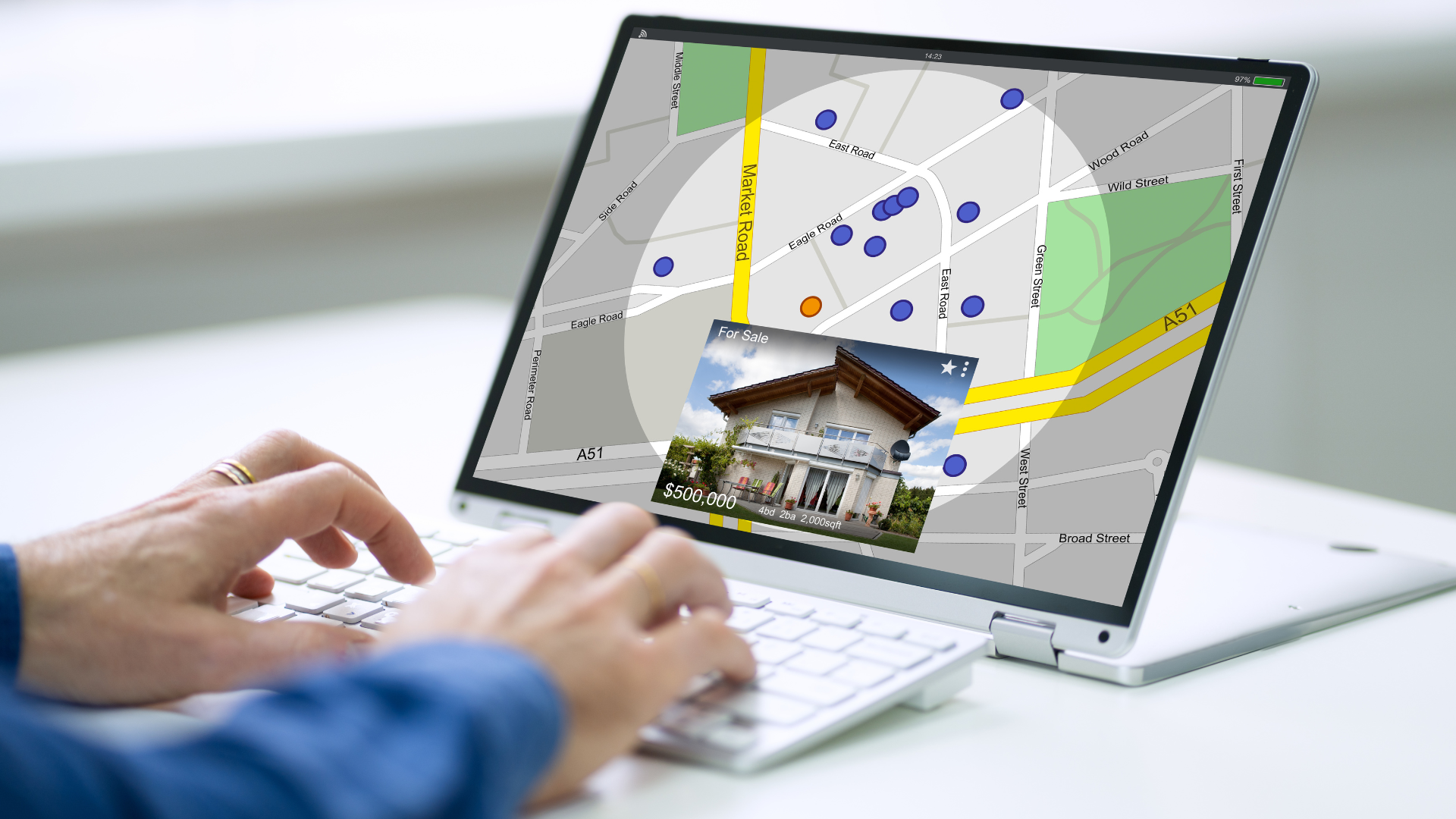 A person is typing on a laptop computer with a map on the screen.