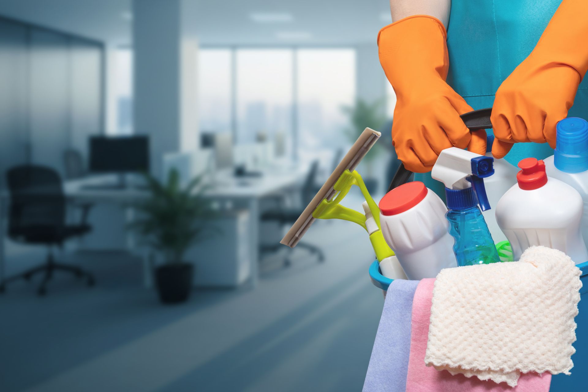 Gloved hands holding cleaning supplies and cloths in an office setting