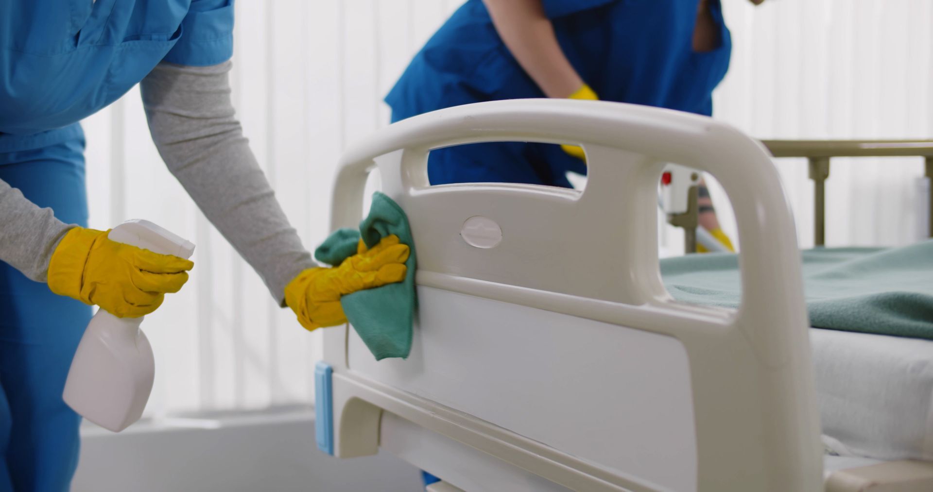 A group of janitors are disinfecting a hospital room.