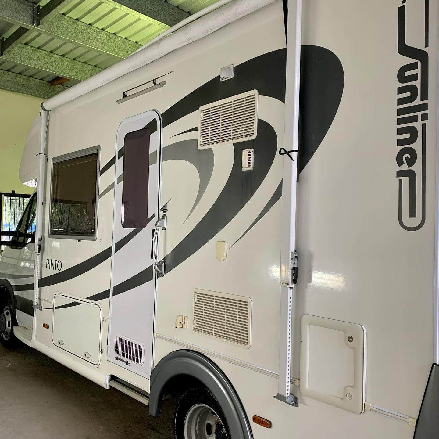 A White And Black Rv Is Parked In A Garage — Tim Kratzke Detailing in Pialba, QLD