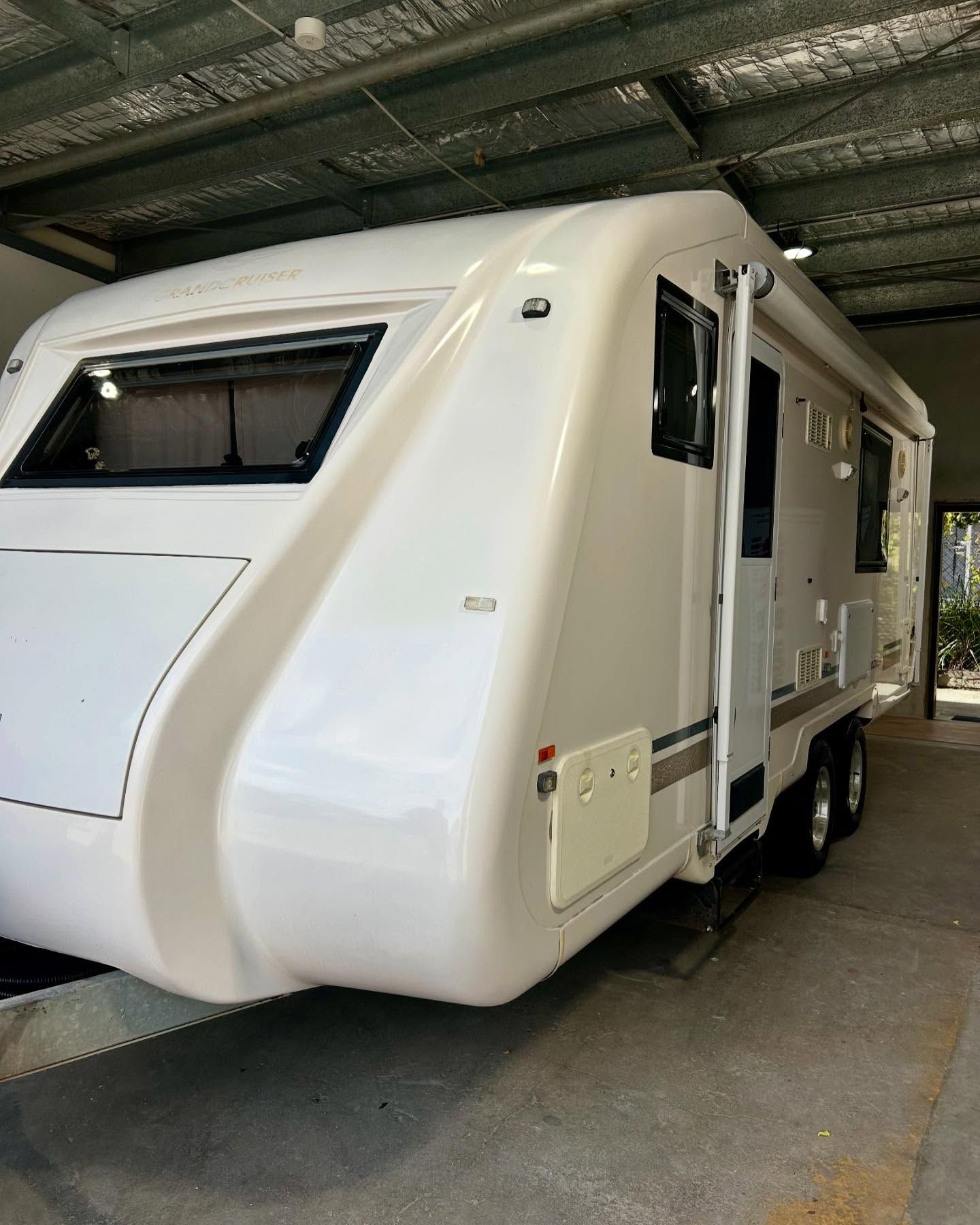 A White RV Is Parked In A Garage  — Tim Kratzke Detailing in Pialba, QLD