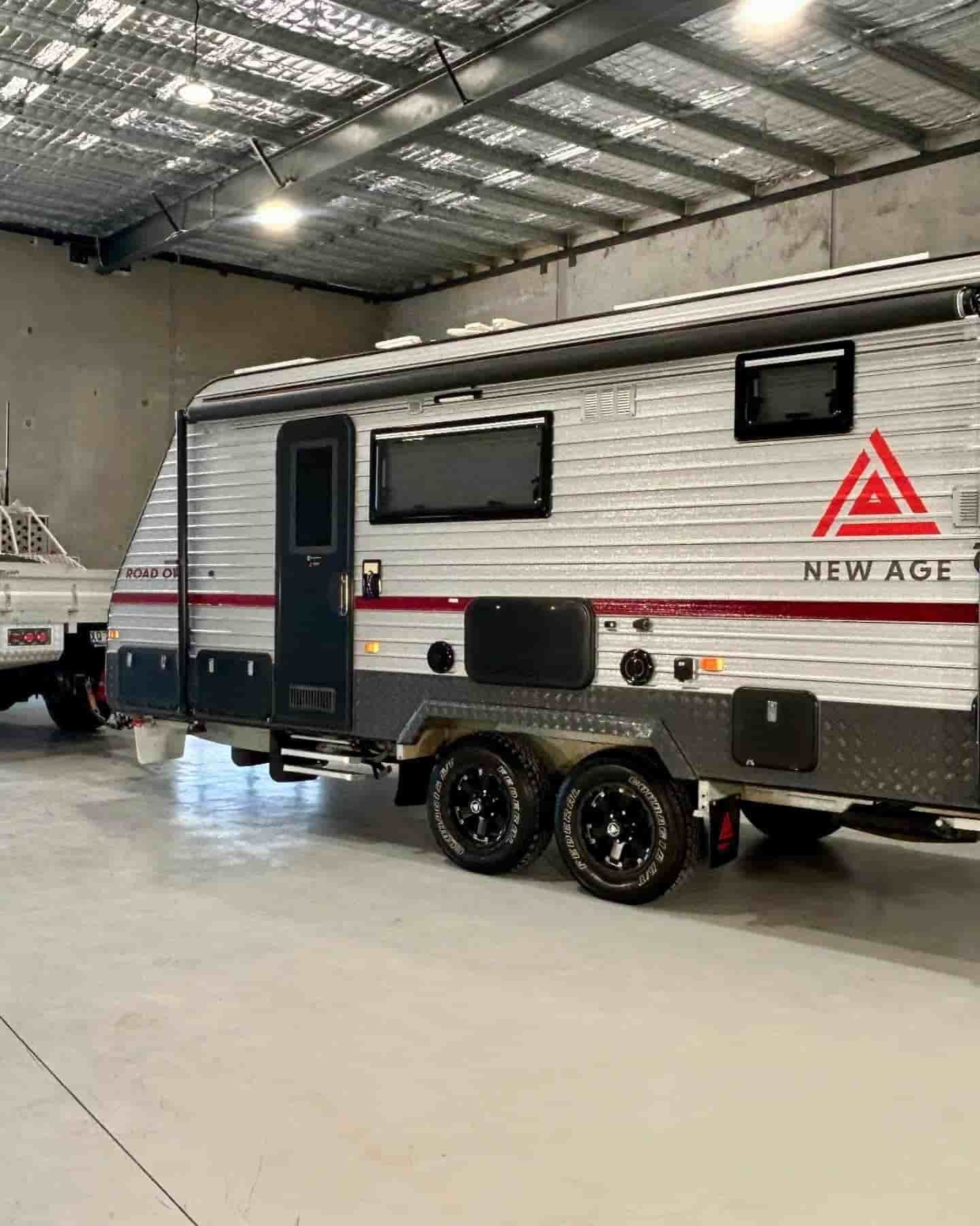 A Camper Trailer Is Parked In A Garage Next To A Truck  — Tim Kratzke Detailing in Pialba, QLD