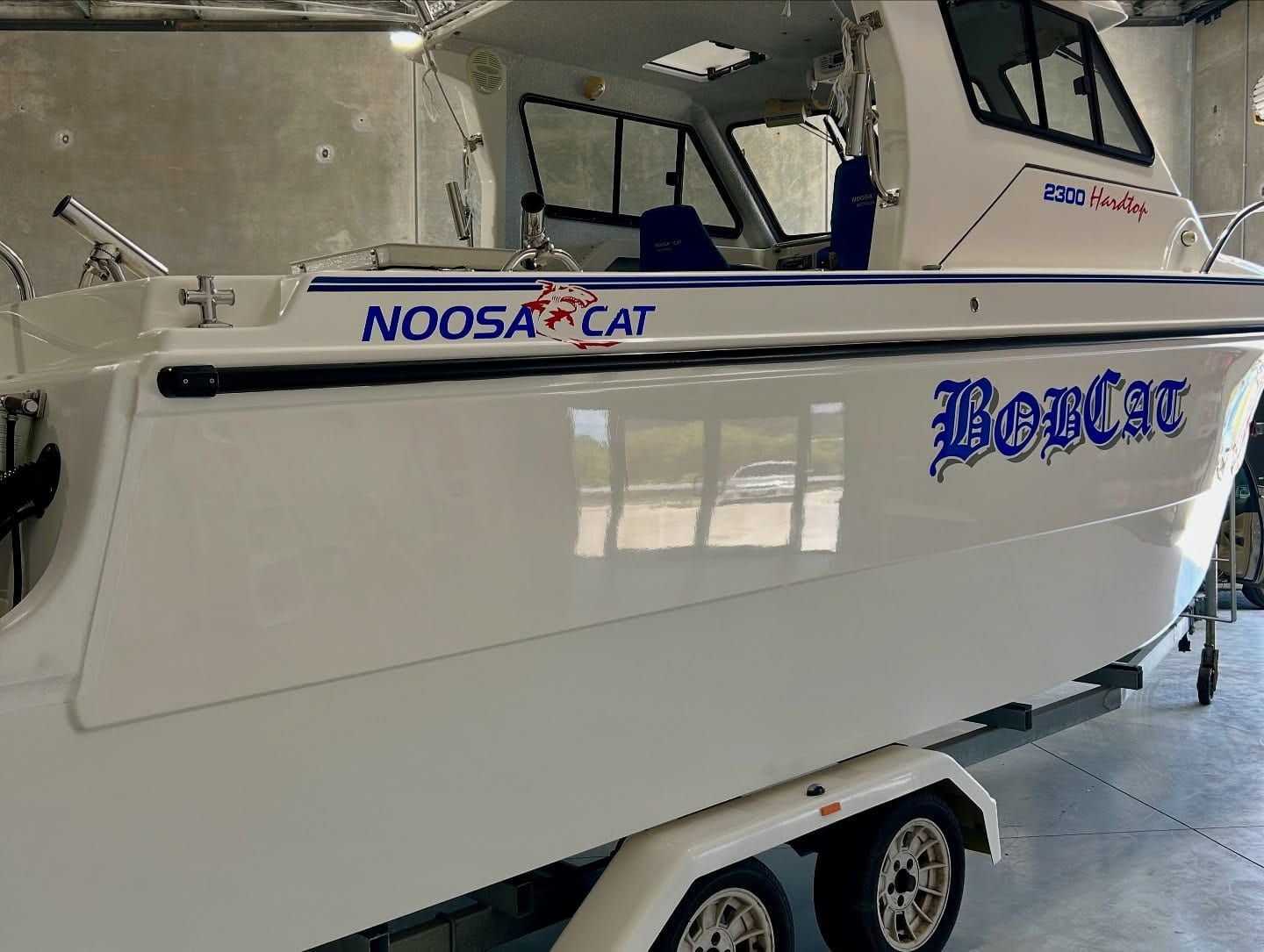 A White Boat With The Word Noosa Cat On The Side Is On A Trailer — Tim Kratzke Detailing in Pialba, QLD