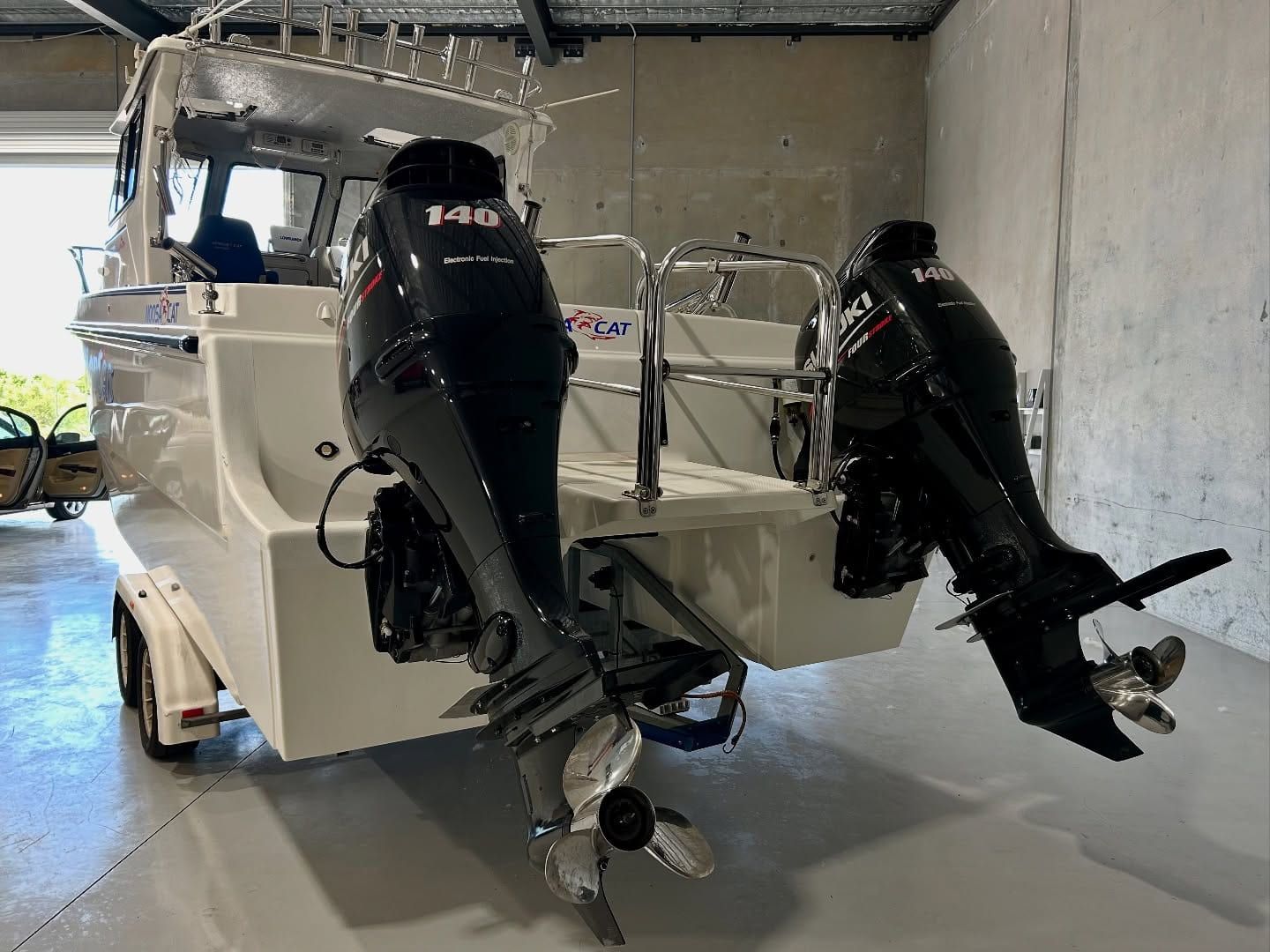 A Boat With Two Outboard Motors Is Parked In A Garage — Tim Kratzke Detailing in Pialba, QLD