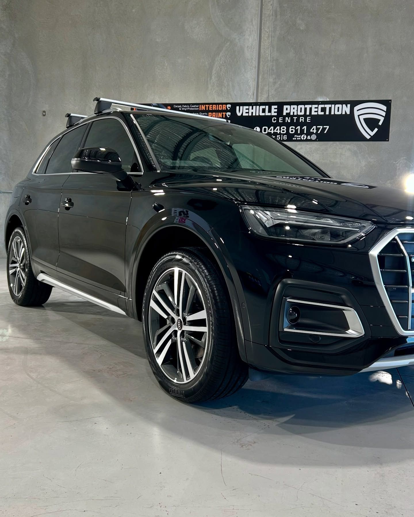 Black Audi SUV parked indoors near a sign for vehicle protection — Tim Kratzke Detailing in Pialba, QLD