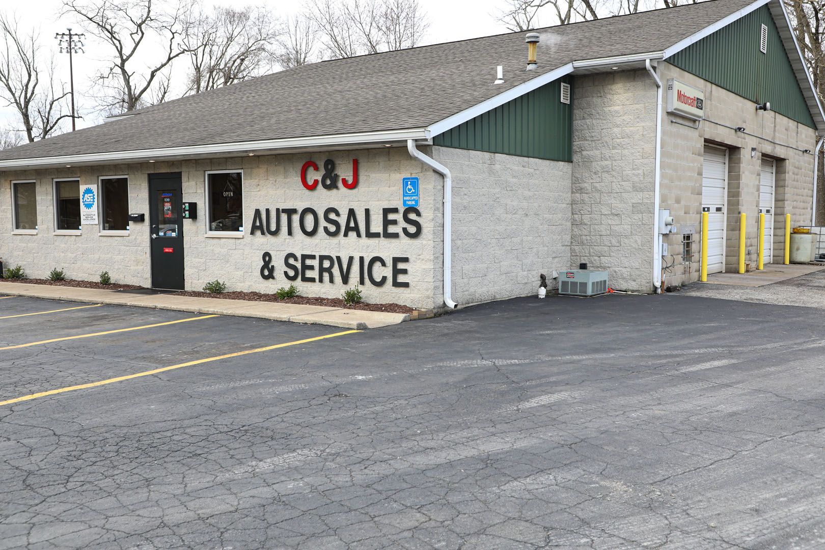 C&J Autosales & Service building with brick exterior, garage bays, and parking lot