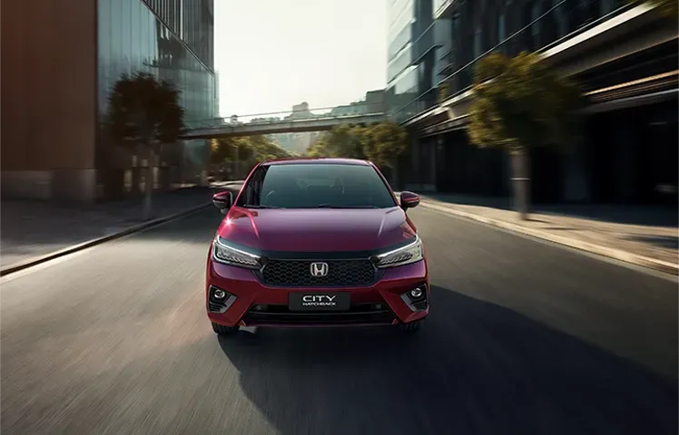 Um Honda Civic vermelho dirigindo em uma rua da cidade com efeito de desfoque de movimento.