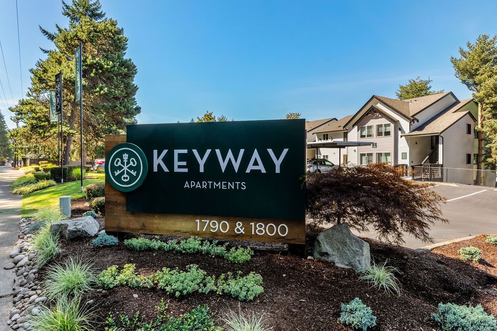 Sign for Keyway Apartments, green and white text, set at 1790 & 1800. Apartment building in background.