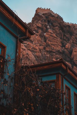 Single-story gray house with desert landscaping in a suburban neighborhood, mountains in the background