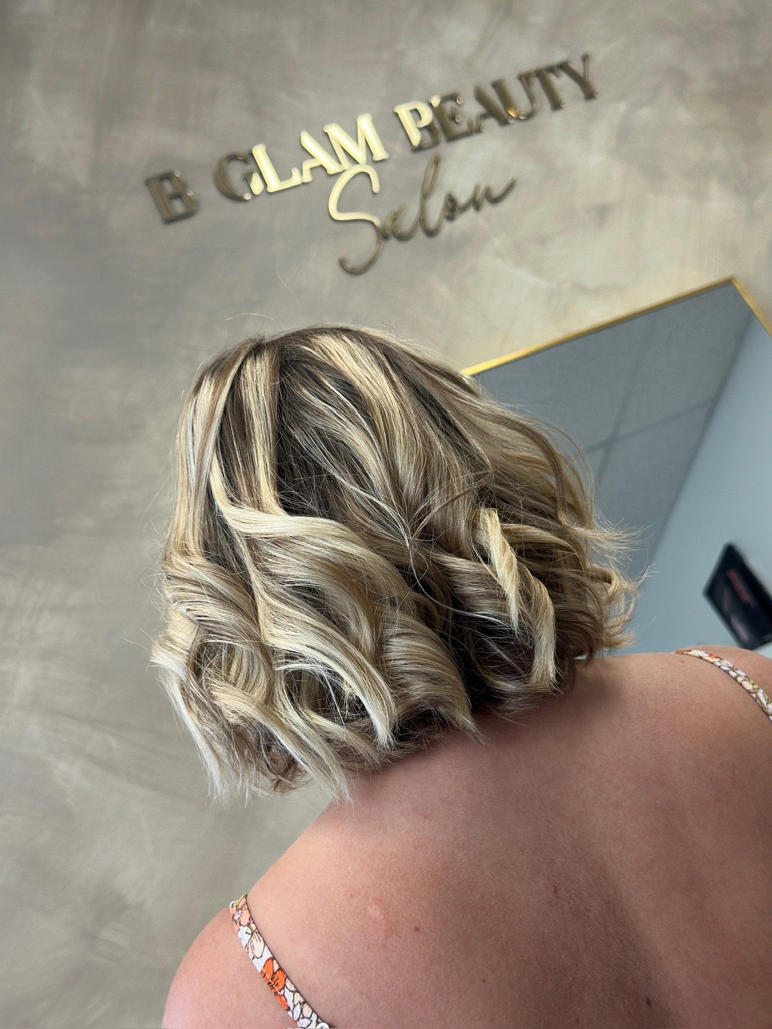 a lady in a salon with short brown hair with blond highligts