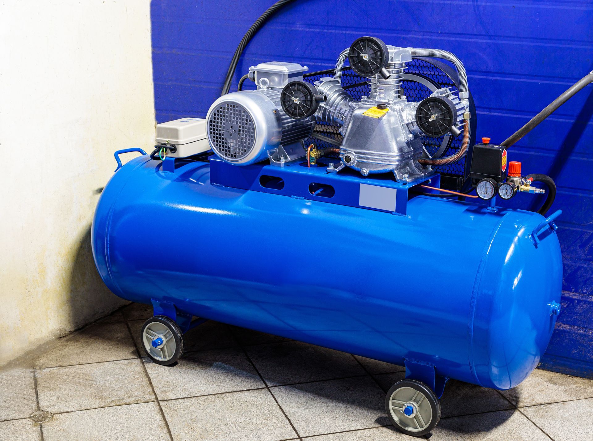 New industrial air compressor with a blue motor and pressure gauge