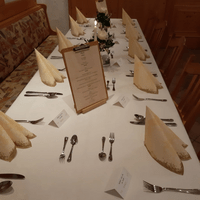 Ein langer Tisch mit Besteck und einer Speisekarte darauf
