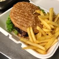 Ein Hamburger und Pommes Frites in einem Styroporbehälter.