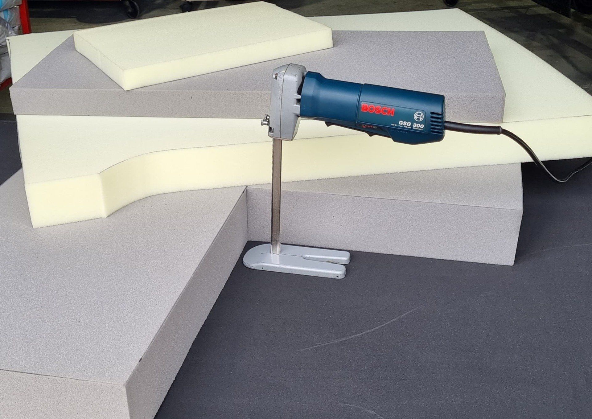 A Bosch Foam Cutter Is Cutting A Piece Of Foam — Manning Pools, Rubber & Foam In Taree, NSW