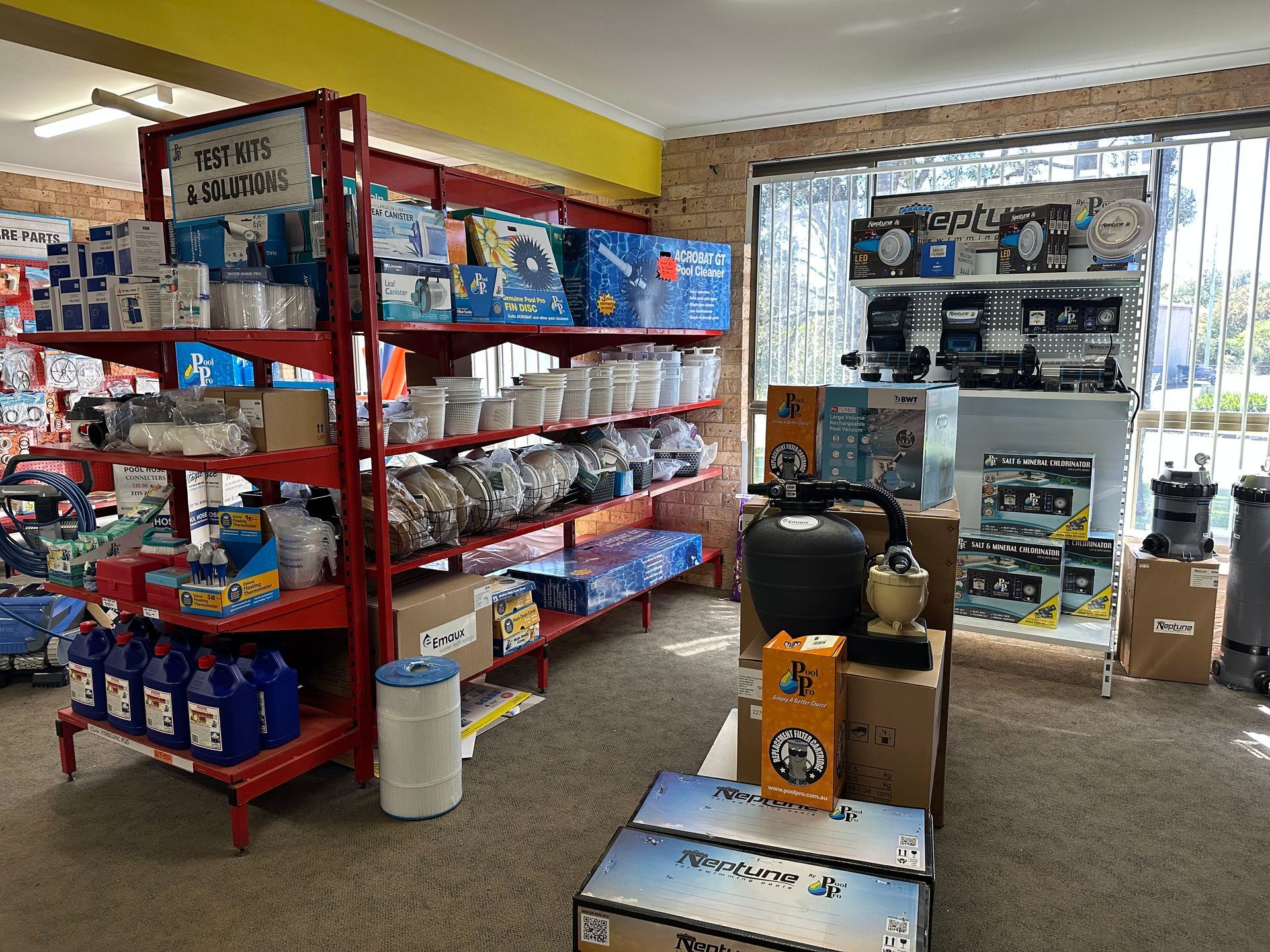 Interior of a retail store with red shelves stocked with pool supplies. — Manning Pools, Rubber & Foam In Taree, NSW