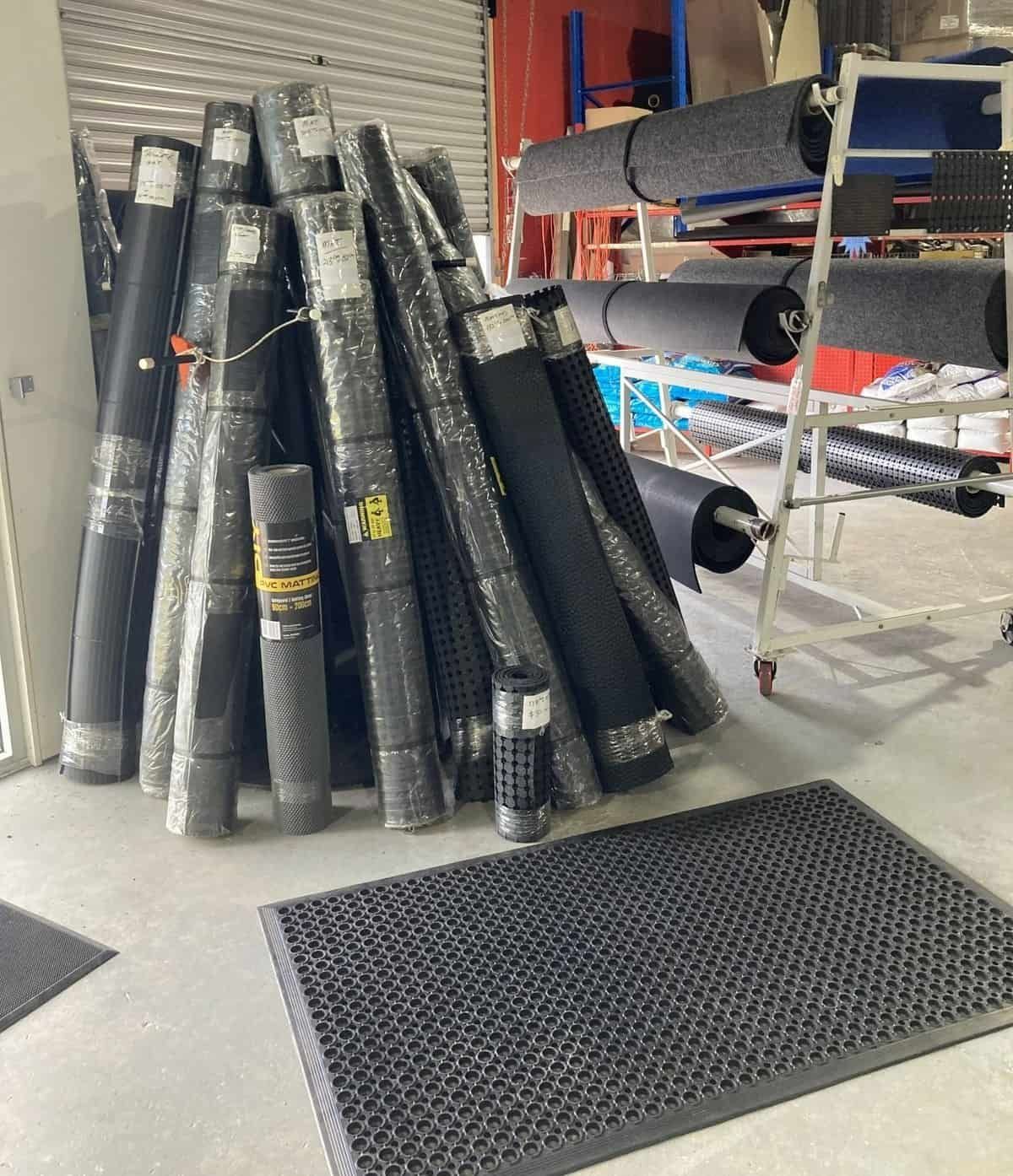 A Bunch Of Rolls Of Carpet Are Stacked On Top Of Each Other In A Room — Manning Pools, Rubber & Foam In Taree, NSW
